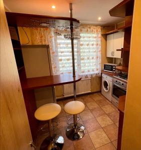 a kitchen with a table and two stools at Klaipeda City in Klaipėda