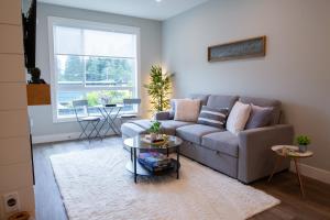 a living room with a couch and a table at New 1 Bed Condo with Mtn Views in Harrison Hot Springs