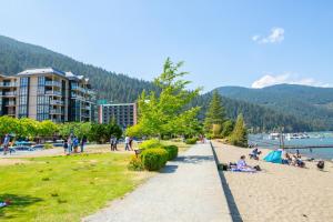 a group of people on a beach near the water at New 1 Bed Condo with Mtn Views in Harrison Hot Springs