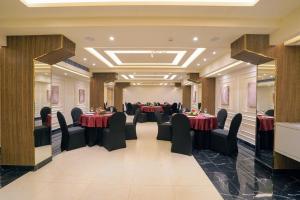 a banquet hall with tables and chairs in a room at Hotel Le Jardin in Erode