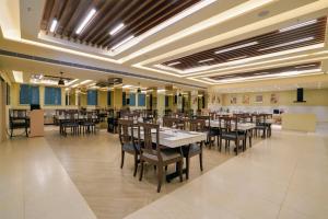 a large dining room with tables and chairs at Hotel Le Jardin in Erode