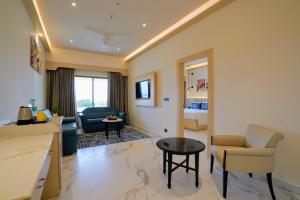 a living room with a couch and a table at Hotel Le Jardin in Erode