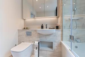 a bathroom with a toilet and a sink and a shower at 3 Bed Duplex, Pool Table, 4 Stops to Wembley in Hatch End +42 photos