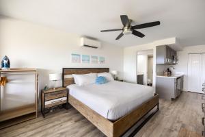 a bedroom with a bed and a ceiling fan at Beachside Maui studio with pool & hot tub access in Wailea +51 photos