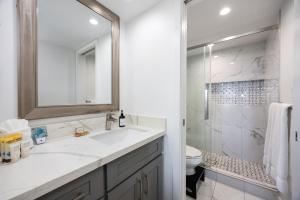 a white bathroom with a sink and a shower at Beachside Maui studio with pool & hot tub access in Wailea
