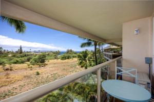 a balcony with a table and a view of a field at Beachside Maui studio with pool & hot tub access in Wailea