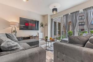 a living room with two couches and a tv at 3 Bed Duplex, Pool Table, 4 Stops to Wembley in Hatch End