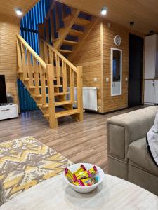a living room with a staircase and a bowl on a table at WoodCottage in Borjomi