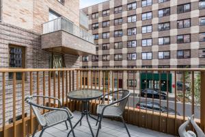 a balcony with a table and chairs and a building at 3 Bed Duplex, Pool Table, 4 Stops to Wembley in Hatch End