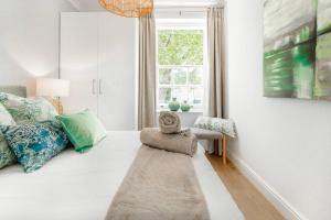 a white room with a bed and a window at Quiet Central Home Near Newlands Cricket in Cape Town