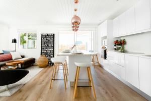 a kitchen and living room with a table and stools at Quiet Central Home Near Newlands Cricket in Cape Town