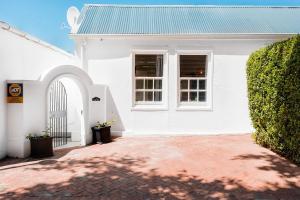 a white house with a green roof and a driveway at Quiet Central Home Near Newlands Cricket in Cape Town