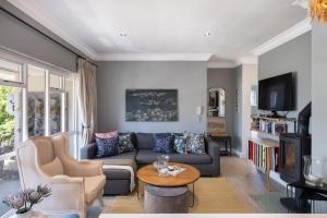 a living room with a couch and a tv at Quiet Garden Flat Near Kenilworth Centre in Cape Town