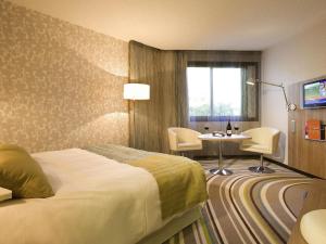 ein Hotelzimmer mit einem Bett und einem Tisch in der Unterkunft Mercure Angers Centre de Congrès in Angers