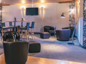Ein Wartezimmer mit Stühlen, einem Tisch und einem Fernseher in der Unterkunft Mercure Angers Centre de Congrès in Angers