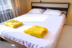 two yellow towels sitting on top of a bed at Poltava Green Apartments in Poltava