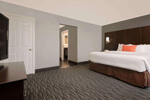 Een bed of bedden in een kamer bij Hawthorn Suites by Wyndham Columbus West