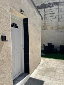a white door in the side of a building at Studio Zoo & Châteaux in Faverolles-sur-Cher