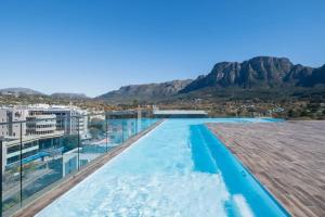 a swimming pool with mountains in the background at Newlands Peak Luxury Suite in Cape Town