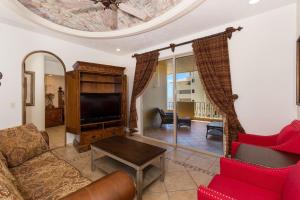 a living room with a couch and a tv at Bella Sirena 601-B -Stylish Condo in Oceanfront Resort in Puerto Peñasco
