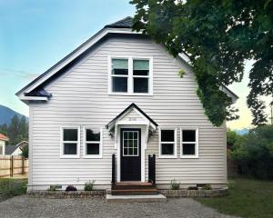 a white house with a black door and windows at Home Town Mountain Lodging 2 in Darby