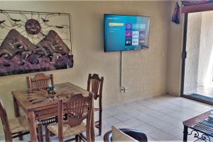 a dining room with a table and a tv on the wall at Sonoran Spa 304-N in Puerto Peñasco