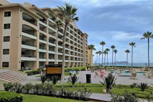 a large apartment building with palm trees in a park at Sonoran Spa 304-N in Puerto Peñasco