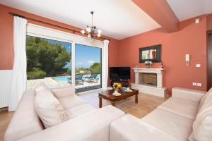 a living room with a white couch and a fireplace at Villa Eudora in Tsoukalades