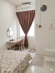 a bedroom with a bed and a desk and a window at Eden Vista in Kuantan