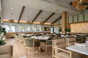 a restaurant with tables and chairs and windows at Guesthouse Hotel at La Valle in Rancho Santa Fe
