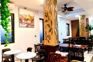 a restaurant with tables and chairs and a ceiling fan at Apple Phu Quoc Hotel & Restaurant in Phú Quốc