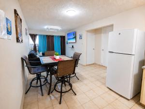a kitchen with a table and a white refrigerator at 30 seconds beach aparment in Aguacate