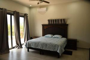 a bedroom with a bed and a ceiling fan at Casa de Cuatro Vientos in Álamos +37 photos