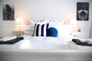 a white bed with a blue ball on top of it at The Sampson - Orange in Orange
