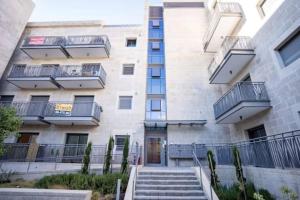 an apartment building with stairs in front of it at 1 Br Apartment In Shaul Adler in Jerusalem