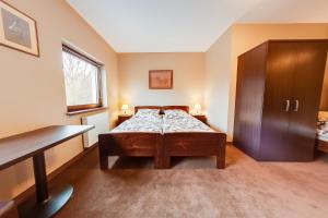 um quarto com uma cama e um armário de madeira em Hotel Restauracja Biały Las Wierzbna em Żarów