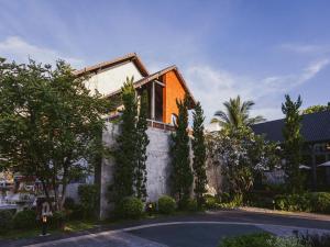 a house on a street with trees at R-Mar Resort and Spa Patong, Phuket in Patong Beach