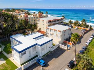 an aerial view of a white building and the ocean at 30 seconds beach aparment in Aguacate