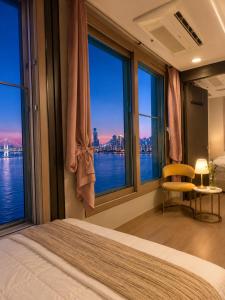 a bedroom with a large window with a view of the water at Crystal Ocean House 무료주차 in Kwangan-dong