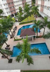 an overhead view of a pool with palm trees and buildings at LuxeInn in Trece Martires