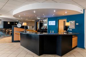 eine Bar in einem Restaurant mit einer Uhr an der Wand in der Unterkunft Holiday Inn Express Newcastle Gateshead by IHG in Newcastle upon Tyne