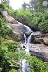two people standing in front of a waterfall at Glen Brooks Resorts in Calicut
