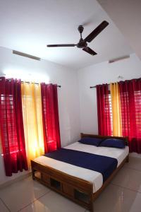 a bedroom with a bed with colorful curtains at Glen Brooks Resorts in Calicut