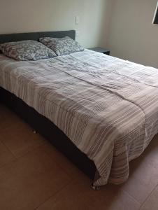 a bed with a striped blanket on top of it at Natura suite's & eventos in Guadalajara +8 photos