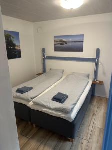 a pair of beds in a room with paintings at Charmig stuga i Abbekås in Abbekås