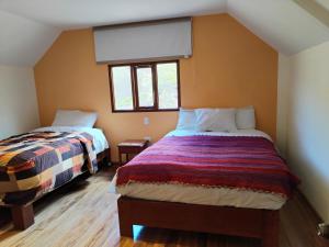 a bedroom with two beds and two windows at Apu Tacllo lodge in Layo