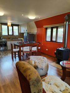a living room with red walls and a table and chairs at Apu Tacllo lodge in Layo
