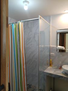 a shower with a glass door in a bathroom at Apu Tacllo lodge in Layo