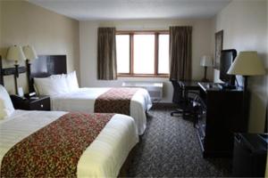 a hotel room with two beds and a desk at Valley Inn Sanford Medical Center in Sioux Falls