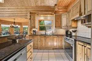 a kitchen with wooden cabinets and a counter top at Fiddler Lake Resort - Deer 47 in Mille-Isles